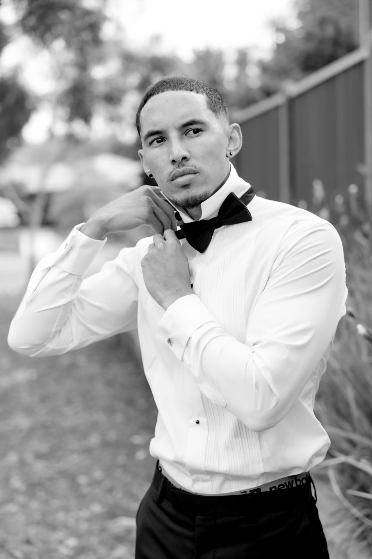Groom adjusting his bow tie