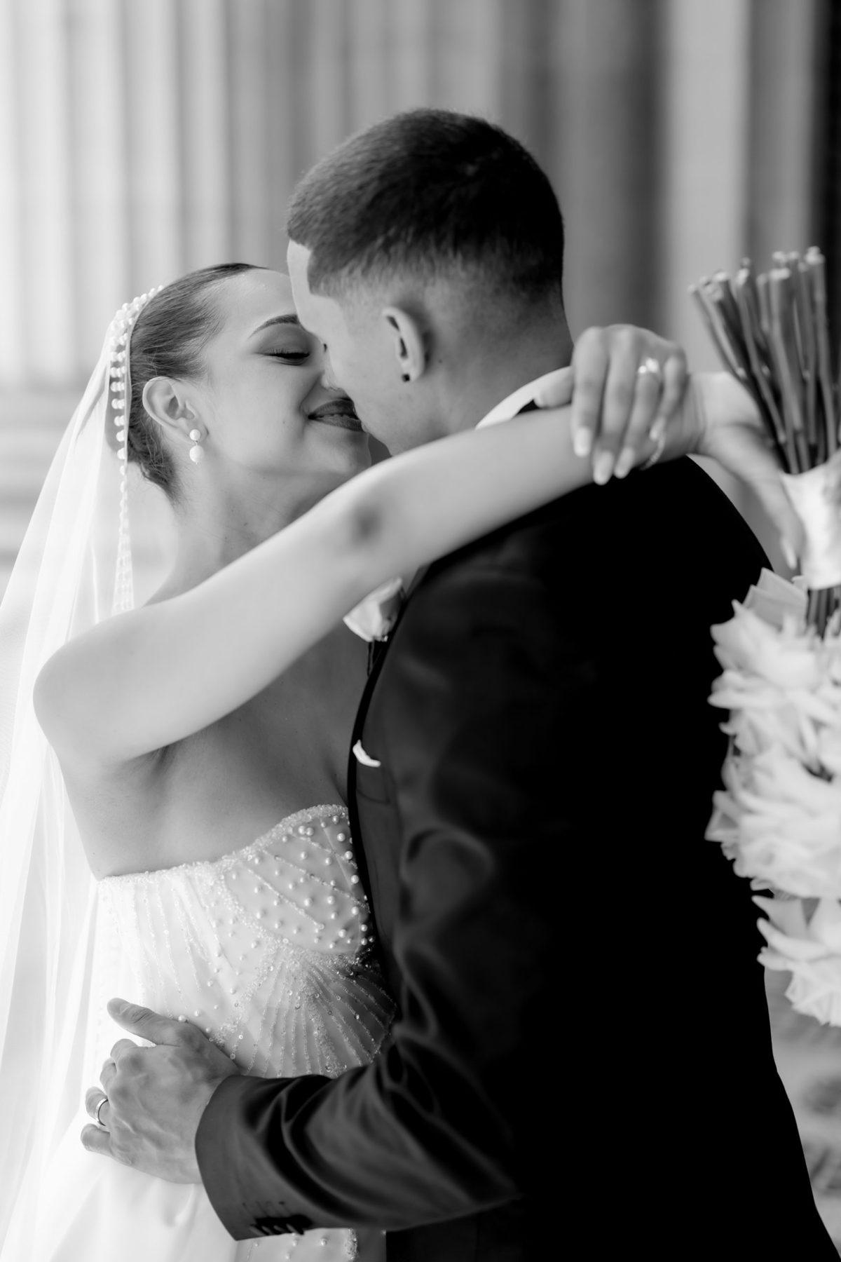 Couple sharing a kiss, her arms wrapped around his neck