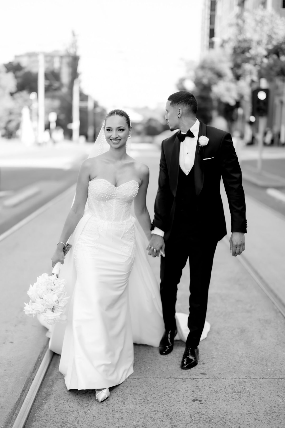 Couple walking hand in hand down the tram tracks